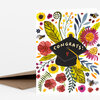 A folded greeting card with a floral and bee illustration featuring a black graduation cap and the word "CONGRATS!" on the front.