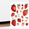 A greeting card featuring multiple watercolor strawberries and the handwritten text "grateful for you" in the center.