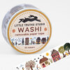 A roll of washi tape labeled "LITTLE TRUTHS STUDIO WASHI removable paper tape 10 meters" with a neighborhood illustration band around the side and a sample strip showing small houses, trees, and people.