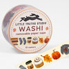 A roll of washi tape labeled "LITTLE TRUTHS STUDIO WASHI removable paper tape 10 meters" with illustrated fall motifs including pumpkins, leaves, a sweater, coffee cup, cinnamon roll, socks, and books.