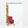 A lined notepad with the headline "READ ALL THE BOOKS. DO ALL THE THINGS." and an illustration of stacked books beside a red armchair, table, and mug, with a round label reading "NOTEPAD 50 PAGES RECYCLED PAPER little truths studio".