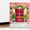 A greeting card featuring an illustration of a red front door with a holiday wreath, two potted Christmas trees, and the handwritten text "sending peace, love, and joy to you".