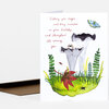 A folded birthday greeting card with the printed message "Wishing you magic and tiny miracles on your birthday and throughout the coming year" and an illustrated scene of white flowers, leaves, and small insects.