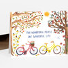 A greeting card with watercolor illustrations of two trees, flowers, two bicycles, and the text "TWO WONDERFUL PEOPLE ONE WONDERFUL LIFE."
