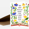 A folded greeting card shows hand-painted flowers and ladybugs around an open book, with the text "YOU HAVE BEEN IN EVERY LINE I HAVE EVER READ. -CHARLES DICKENS" on the front.