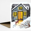 A folded greeting card shows a snowy house with lit yellow windows and two dogs standing at the front door.