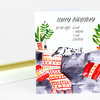 A folded birthday notecard with the text "HAPPY BIRTHDAY" and "to-do list:" above a handwritten-style checklist, featuring illustrated potted plants and a cat lounging on patterned furniture.