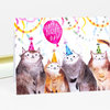 A folded notecard with a watercolor illustration of four party-hat cats and a pink balloon that reads “HAPPY BIRTHDAY.”