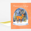 A folded greeting card with the text "Peace and Joy" above an illustration of a deer standing in a snowy scene inside a glass dome.