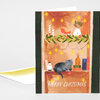 A vertical Christmas greeting card with a black cat on a decorated shelf and the text “MERRY CHRISTMAS” at the bottom.