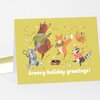 A folded greeting card with a yellow cover featuring dancing animals and the text "Groovy holiday greetings!".