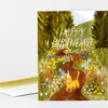 A folded birthday card with a painted scene of a yellow cat wearing a party hat among wildflowers and the text "HAPPY BIRTHDAY!" on the front.