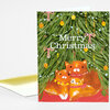 A folded holiday greeting card with an illustrated Christmas tree and three orange cats, featuring the text "Merry Christmas" on the front.