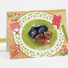 A folded holiday greeting card shows two sleeping kittens curled together on a decorated green plate, surrounded by festive red and green patterns and small holiday treats.