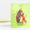 A green notecard featuring two illustrated animals hugging with small leaves around them and the word "HUG" printed at the bottom.