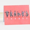 A folded coral-pink notecard with six illustrated gray cats arranged to spell "THANKS" in white letters.