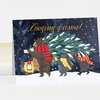 A holiday notecard shows the text "Christmas is coming!" above an illustrated bear and two smaller animals carrying a snow-covered Christmas tree in the snow.