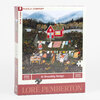 A boxed jigsaw puzzle package labeled "At Brambly Hedge" and "500 PIECES" with artwork of a red house, people hanging laundry, and the name "LORÉ PEMBERTON" on the front.