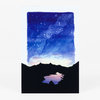 A postcard-sized print with a blue starry sky above a black mountain silhouette and a small pastel-toned reflective shape near the bottom.