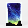 A postcard-sized art print showing a black silhouette of rocky hills beneath a blue-to-green starry sky.