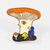 An enamel pin shaped like a stylized mushroom with an orange cap, cream stem, and small colorful mushrooms and spores at the base.