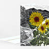 A folded greeting card with a black-and-white landscape illustration and large yellow sunflowers with dark red centers on the front.