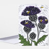 A folded greeting card with a white envelope showing a botanical illustration of purple thistles, green leaves, and several yellow-and-black bees.