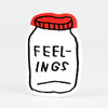 A sticker shaped like a jar with a red lid outline and the hand-drawn text "FEEL-INGS" on the front.