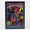 A black-covered horror zine or comic booklet with a colorful illustrated demon woman on the cover and visible text including "MONSTERAMA," "#6," "est 2020," and "YOUR RETRO HORROR ZINE."