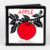A board book with a black cover showing a red apple on a branch with black leaves, the title "APPLE" and the author name "Nikki McClure" on the front.