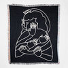 A rectangular black blanket with multicolored fringe and a white line-art figure with multiple hands across the front.