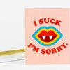 A folded greeting card with a pink front that reads "I SUCK" above a colorful vampire mouth graphic and "I'M SORRY" below it.