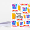 A folded greeting card with colorful illustrated books and small eyeglasses around the centered text "ANOTHER YEAR ANOTHER CHAPTER."