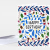A folded greeting card with a white front printed with blue, green, brown, yellow, and purple leaf and berry illustrations framing the words "HAPPY BIRTHDAY" in black.