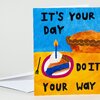 A folded greeting card with colorful hand-drawn cake and pie illustrations and the text "IT'S YOUR DAY DO IT YOUR WAY" on the front.