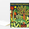 A folded birthday greeting card with the text "HAVE A DINO-MITE BIRTHDAY" and an illustration of a green long-neck dinosaur among colorful tropical plants.