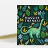 A greeting card with a black cover patterned with colorful tropical leaves and a green dinosaur, with the text "MASSIVE THANKS!" in the center.