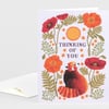 A folded greeting card with a floral illustration and a red panda, featuring the text "THINKING OF YOU."