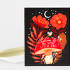 A greeting card with a black front featuring orange-red flowers, leaves, stars, a crescent moon, a small mouse, and the text "welcome to the world LITTLE ONE!" above a mushroom.