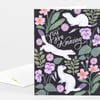 A folded greeting card with a black front cover featuring the hand-lettered words "You Are Amazing" surrounded by white ferrets and pink and purple flowers and leaves.
