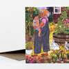 A folded greeting card featuring an illustration of an older woman holding a child in a vegetable garden with chickens, flowers, and leafy plants.
