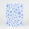 A small notebook with rounded corners and a white cover printed with a repeating blue pattern of moons, suns, stars, birds, butterflies, flowers, leaves, mushrooms, acorns, a house, and other illustrated motifs.