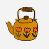 A gold-tone enamel pin shaped like a yellow kettle with a brown handle and spout, decorated with three orange tulip designs.