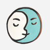 A round enamel pin showing a stylized full moon face split into white and turquoise halves with black outlines and simple closed eyes and mouth.