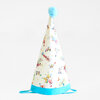 A cone-shaped party hat with a blue pom-pom top, blue trim, and colorful circus character illustrations, plus blue chin ties.