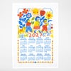 A white tea towel printed with a colorful 2027 calendar, featuring children, flowers, a sun, animals, and month grids.