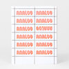 A sheet of orange rubber stamps arranged in a grid, each printing the word "ANALOG" in a stylized block font, with one impression printed upside down.