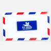 A blue rectangular enamel pin with scalloped edges and white text reading "BY SNAIL" and "PAR L'ESCARGOT," plus a small white logo above the text.