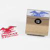 A wooden rubber stamp with a blue bird illustration and a black circular logo with a white "P" on the handle, shown next to a red stamped impression reading "DISSENT is Patriotic."