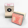 Two small wooden rubber stamps with pink rubber faces, one showing the text "you've got" and the other showing the reversed text "you've got mail" in a candy-cane-style border, with a black circle logo containing a white "P" on one side.